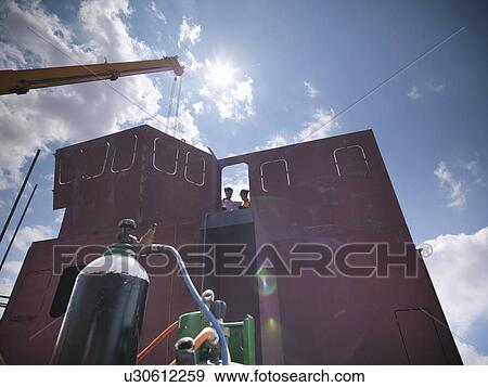 Stock Photo - Engineers examining ship parts. Fotosearch