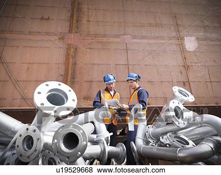Stock Photo - Engineers inspecting ship parts. Fotosearch