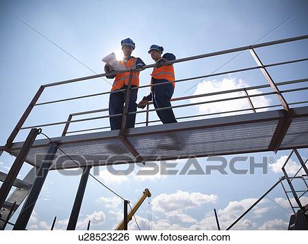 Engineers overlooking ship building View Large Photo Image Stock Photograph - Engineers overlooking ship building. Fotosearch