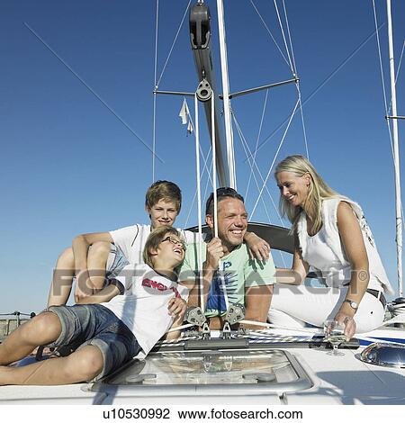 Family relaxing on sailboat View Large Photo Image Stock Image - Family relaxing on sailboat. Fotosearch