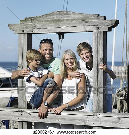 Stock Photo - Family smiling together on pier. Fotosearch