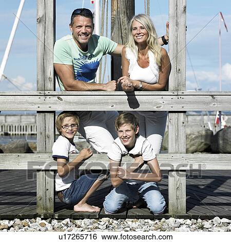 Family smiling together on pier View Large Photo Image Stock Photograph - Family smiling together on pier. Fotosearch