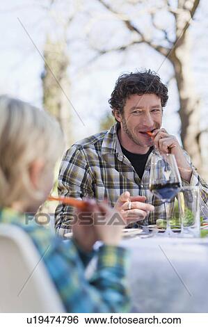 Father and son eating at table outdoors View Large Photo Image Stock Photograph - Father and son eating at table outdoors. Fotosearch