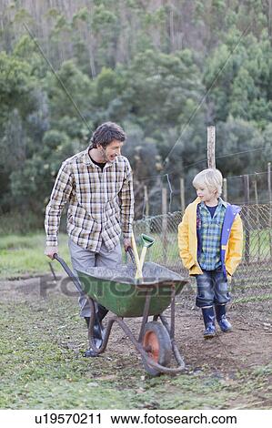 Father and son pushing wheelbarrow View Large Photo Image Stock Image - Father and son pushing wheelbarrow. Fotosearch