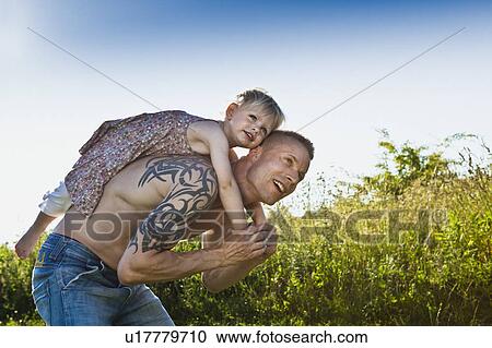 Father carrying daughter on his back View Large Photo Image Stock Image - Father carrying daughter on his back. Fotosearch