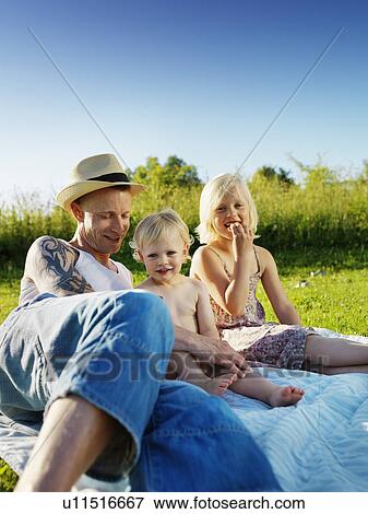 Father laying with daughters outdoors View Large Photo Image Stock Photo - Father laying with daughters outdoors. Fotosearch