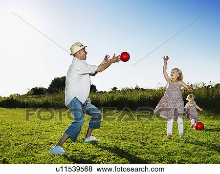 Father playing with daughters outdoors View Large Photo Image Stock Photo - Father playing with daughters outdoors. Fotosearch
