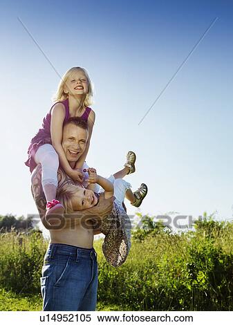 Father playing with daughters outdoors View Large Photo Image Stock Photography - Father playing with daughters outdoors. Fotosearch