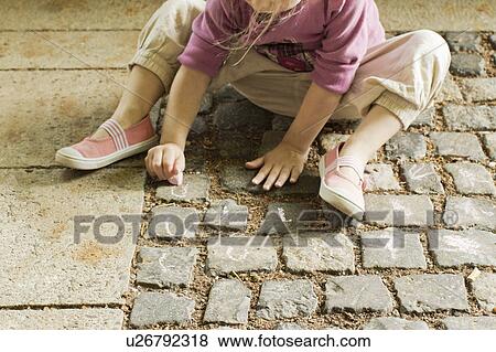Girl drawing with chalk on cobblestone View Large Photo Image Stock Photo - Girl drawing with chalk on cobblestone. Fotosearch
