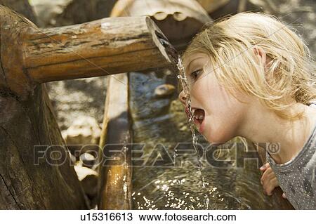 Girl drinking water from spout View Large Photo Image Stock Image - Girl drinking water from spout. Fotosearch