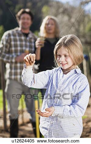 Stock Photography - Girl holding earthworm in garden. Fotosearch