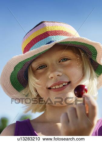 Girl in sunhat holding cherry View Large Photo Image Stock Image - Girl in sunhat holding cherry. Fotosearch