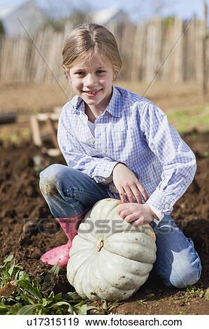 Stock Photo - Girl picking gourd in garden. Fotosearch