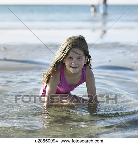 Girl playing in water on beach View Large Photo Image Picture - Girl playing in water on beach. Fotosearch