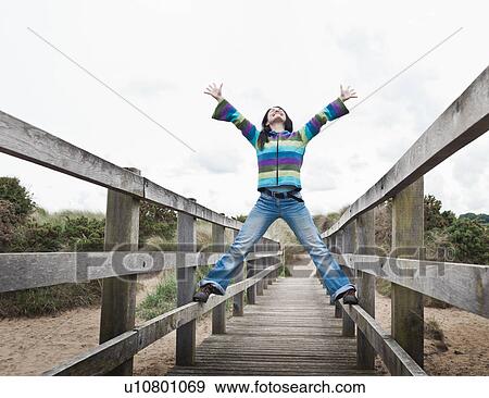 Girl playing on pier on beach View Large Photo Image Stock Photo - Girl playing on pier on beach. Fotosearch