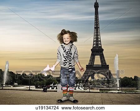 Picture - Girl standing by the Eiffel Tower. Fotosearch