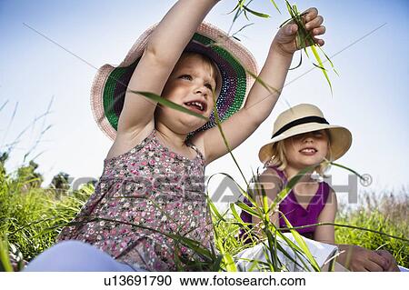 Girls playing in grass together View Large Photo Image Stock Image - Girls playing in grass together. Fotosearch