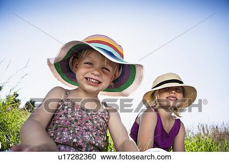 Girls sitting together in grass View Large Photo Image Stock Image - Girls sitting together in grass. Fotosearch