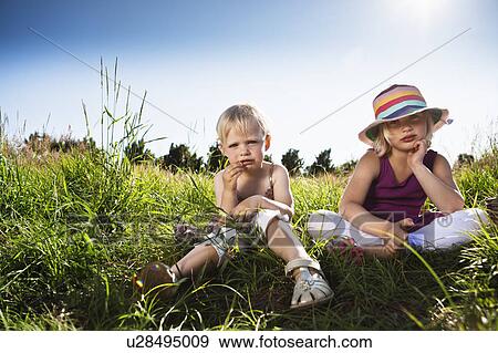 Girls sitting together in grass View Large Photo Image Stock Photo - Girls sitting together in grass. Fotosearch