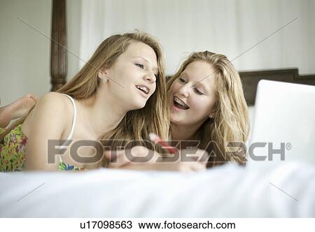 Girls studying together on bed View Large Photo Image Stock Image - Girls studying together on bed. Fotosearch