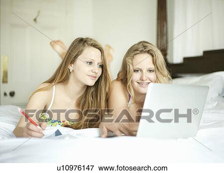 Girls studying together on bed View Large Photo Image Stock Photo - Girls studying together on bed. Fotosearch