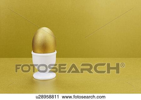 Golden egg in egg cup View Large Photo Image Stock Image - Golden egg in egg cup. Fotosearch