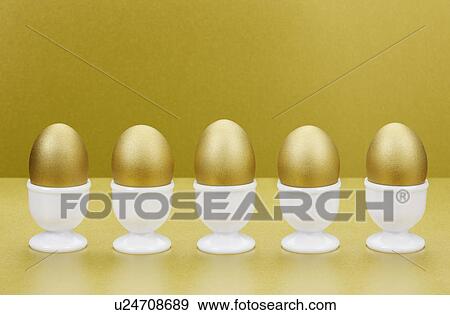 Golden eggs in egg cups View Large Photo Image Stock Photo - Golden eggs in egg cups. Fotosearch
