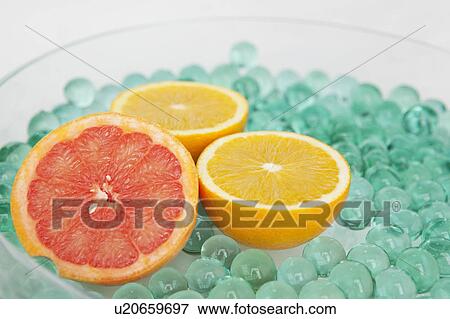 Halved citrus fruits with glass beads View Large Photo Image Stock Photo - Halved citrus fruits with glass beads. Fotosearch