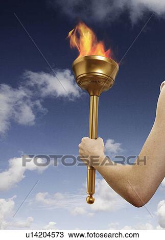 Stock Image - Hand holding flaming baton. Fotosearch