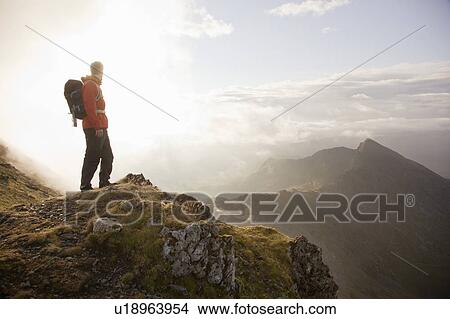 Hiker overlooking view from mountaintop View Large Photo Image Picture - Hiker overlooking view from mountaintop. Fotosearch