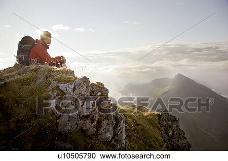 Stock Image - Hiker overlooking view from mountaintop. Fotosearch