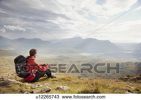 Hiker overlooking view from mountaintop View Large Photo Image Stock Image - Hiker overlooking view from mountaintop. Fotosearch