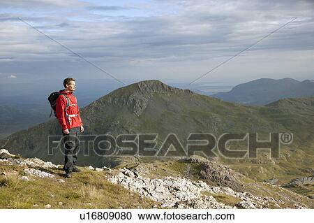 Hiker overlooking view from mountaintop View Large Photo Image Stock Image - Hiker overlooking view from mountaintop. Fotosearch