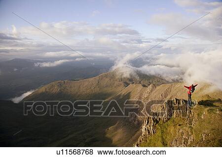 Stock Photo - Hiker overlooking view from mountaintop. Fotosearch