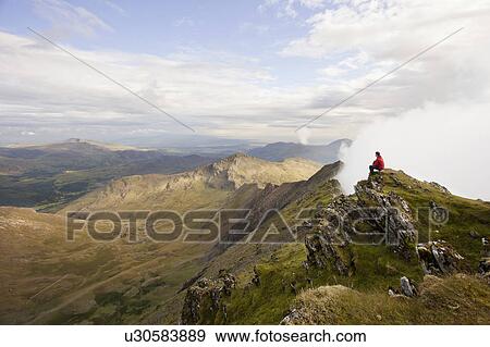 Hiker overlooking view from mountaintop View Large Photo Image Stock Photo - Hiker overlooking view from mountaintop. Fotosearch
