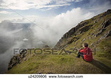 Hiker overlooking view from mountaintop View Large Photo Image Stock Photograph - Hiker overlooking view from mountaintop. Fotosearch