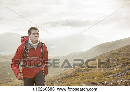 Hiker walking on rocky hillside View Large Photo Image Stock Image - Hiker walking on rocky hillside. Fotosearch