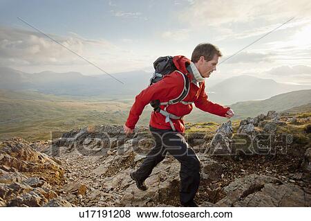 Hiker walking on rocky mountaintop View Large Photo Image Stock Photo - Hiker walking on rocky mountaintop. Fotosearch
