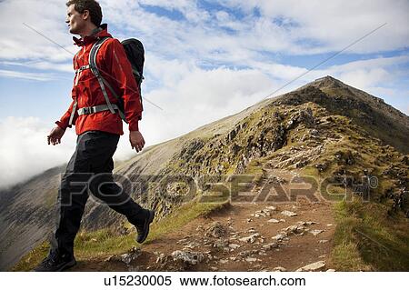 Hiker walking on rocky mountaintop View Large Photo Image Stock Photography - Hiker walking on rocky mountaintop. Fotosearch