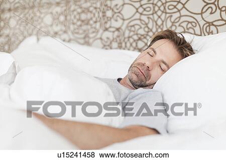 Stock Photo - Man asleep in bed. Fotosearch