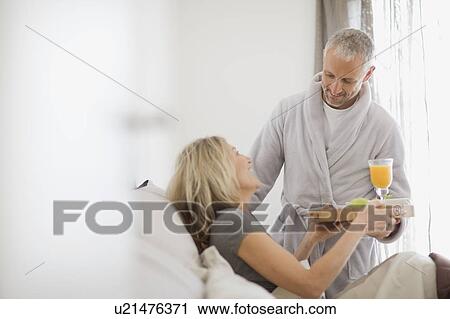 Man bringing wife breakfast in bed View Large Photo Image Stock Image - Man bringing wife breakfast in bed. Fotosearch