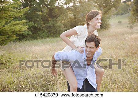 Stock Photo - Man carrying girlfriend piggyback. Fotosearch