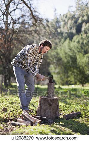 Man chopping wood outdoors View Large Photo Image Stock Image - Man chopping wood outdoors. Fotosearch