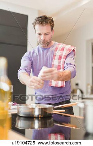 Man cooking dinner in kitchen View Large Photo Image Stock Photography - Man cooking dinner in kitchen. Fotosearch