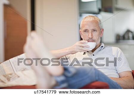 Man drinking coffee in armchair View Large Photo Image Stock Photo - Man drinking coffee in armchair. Fotosearch