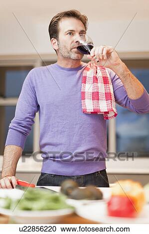Man drinking wine and cooking dinner View Large Photo Image Stock Image - Man drinking wine and cooking dinner. Fotosearch