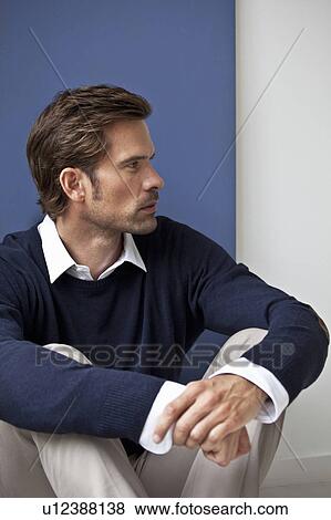 Man hugging his knees on floor View Large Photo Image Stock Photo - Man hugging his knees on floor. Fotosearch