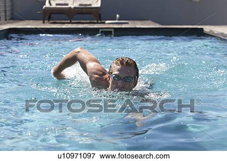 Stock Photo - Man in goggles swimming in pool. Fotosearch