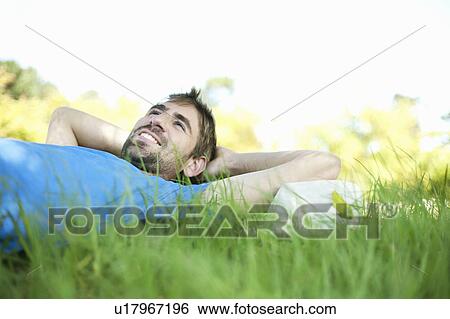 Man laying in tall grass View Large Photo Image Stock Photograph - Man laying in tall grass. Fotosearch