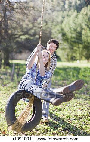 Man pushing girlfriend on tire swing View Large Photo Image Stock Image - Man pushing girlfriend on tire swing. Fotosearch